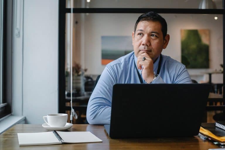 man sitting at laptop looking to make a decision