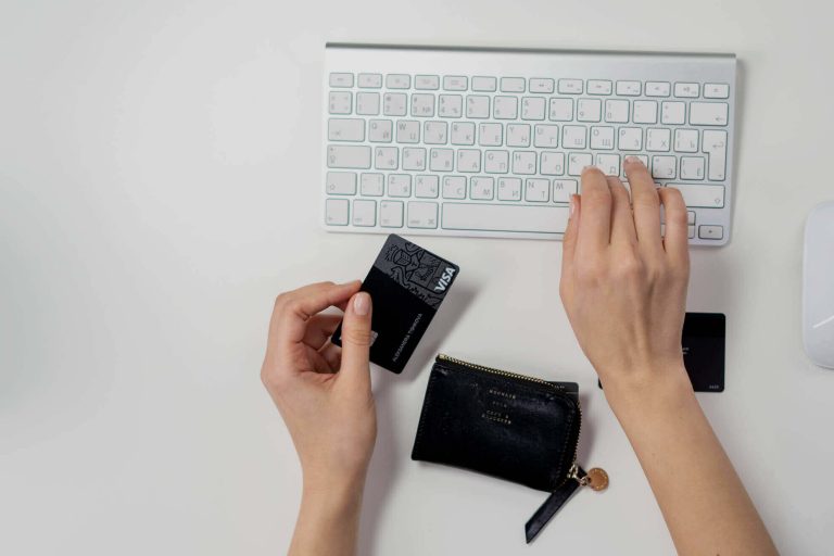 person holding a credit card near a computer keyboard f 0