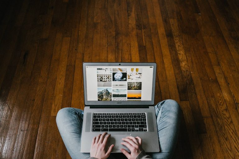 person sitting on floor using laptop