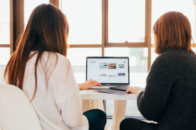 two women looking at laptop computer