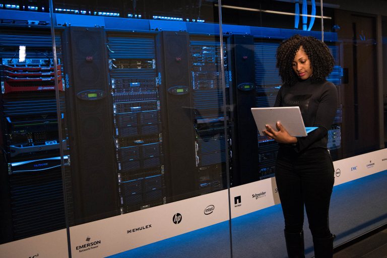 woman looking at laptop in data center